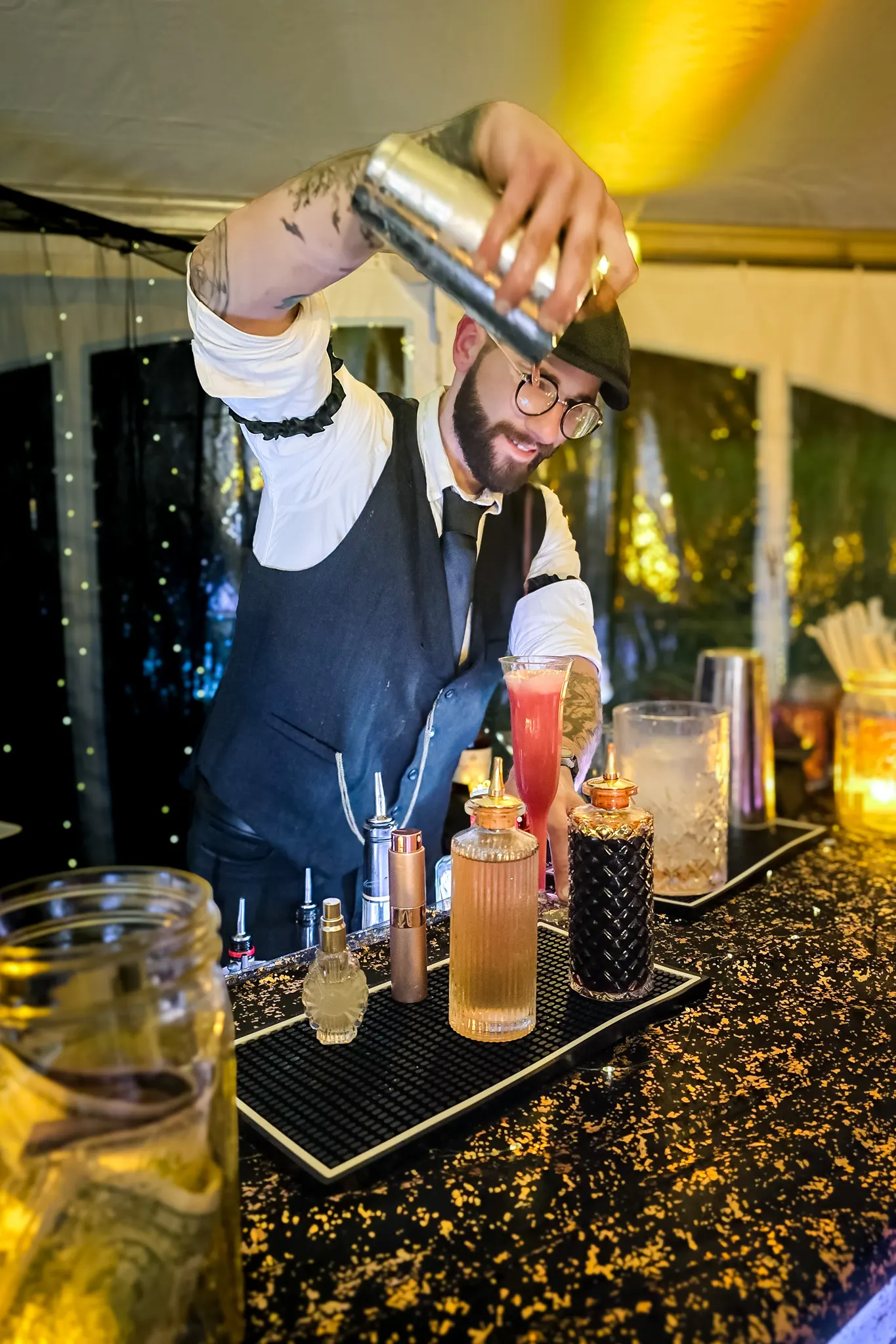 Bartender pouring a signature cocktail at the tented Serbian Festival bar