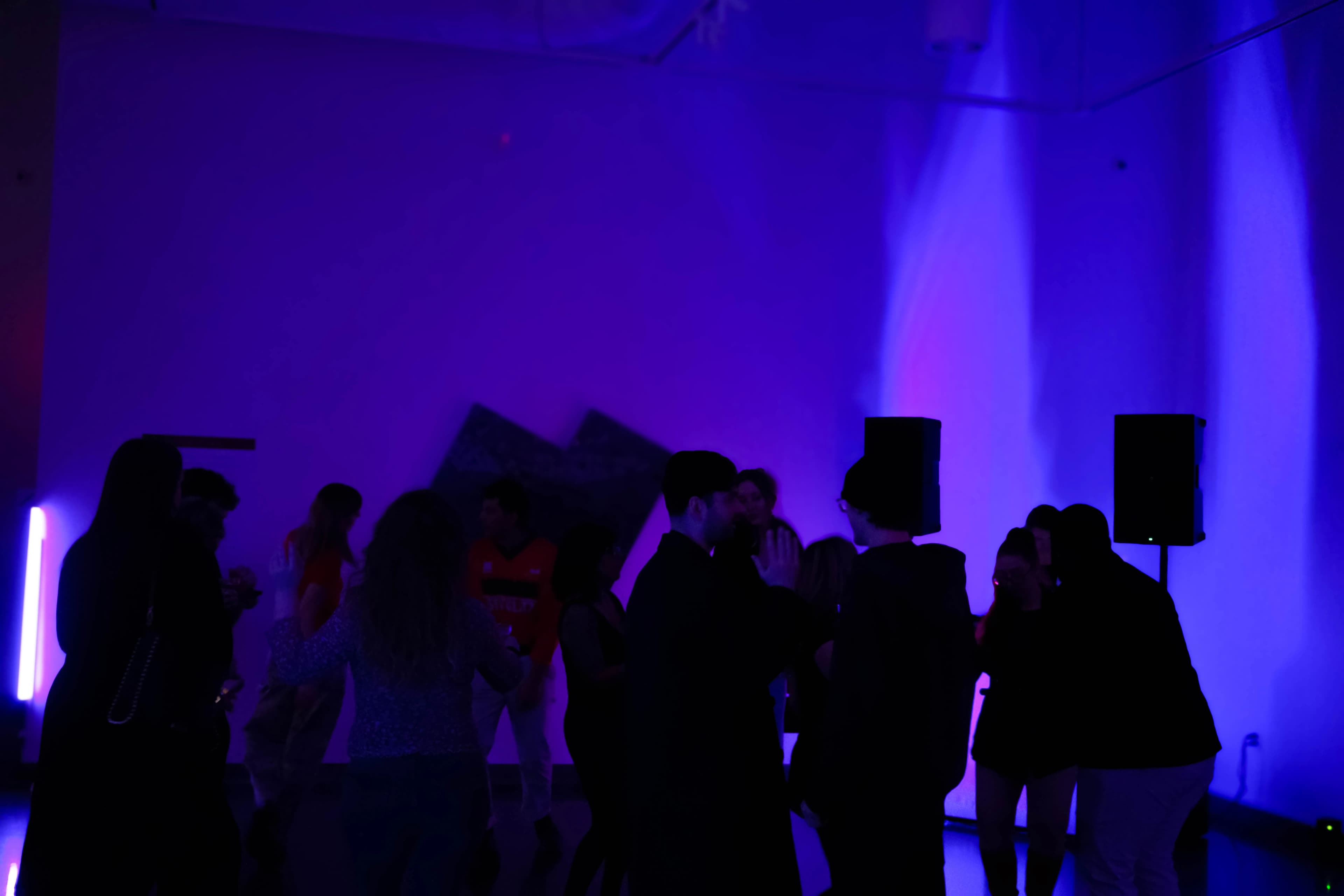 Shot of a neon-lit room with people dancing at a Split Base event