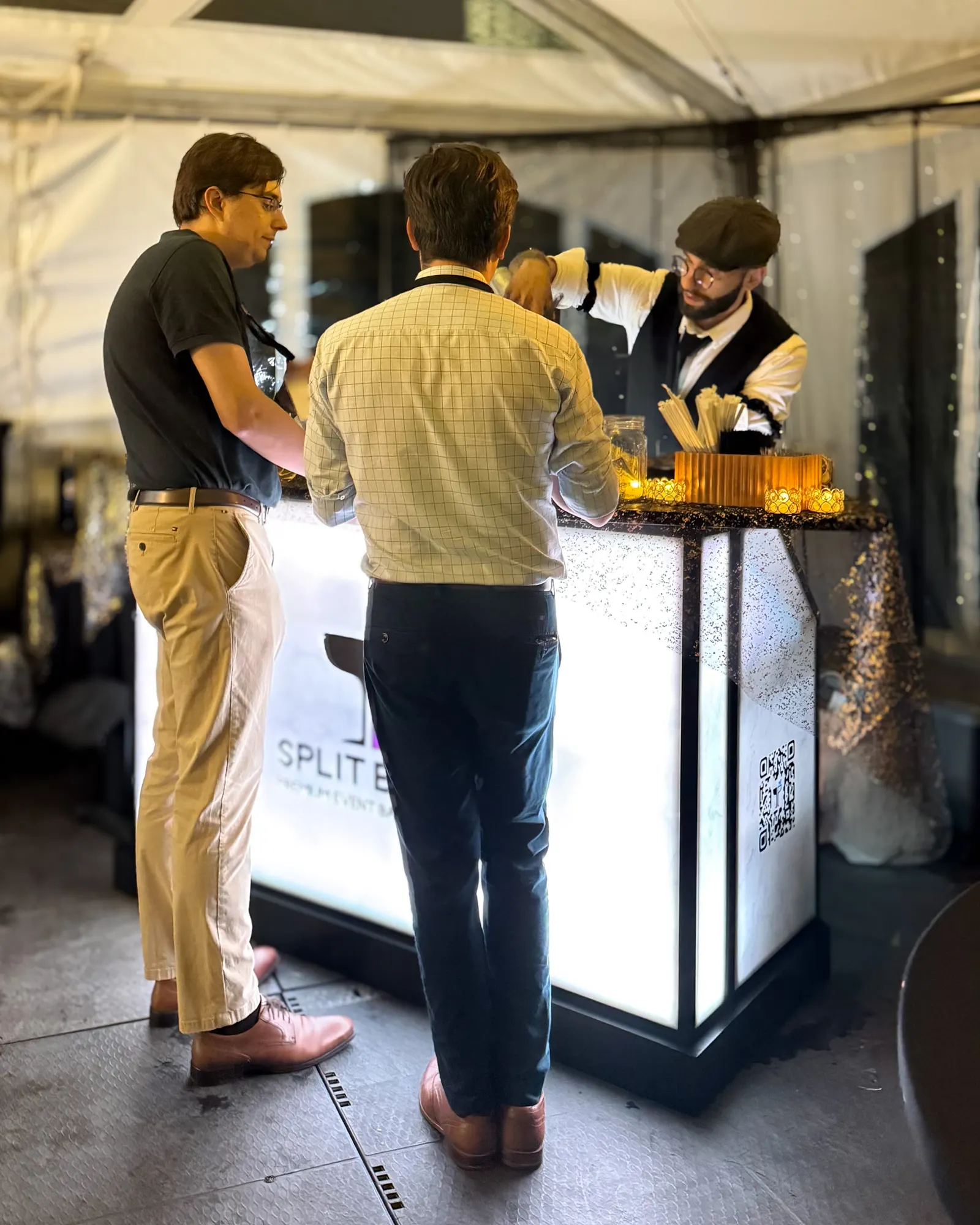 Festival guests gathered at the glowing bar under the tent after dark