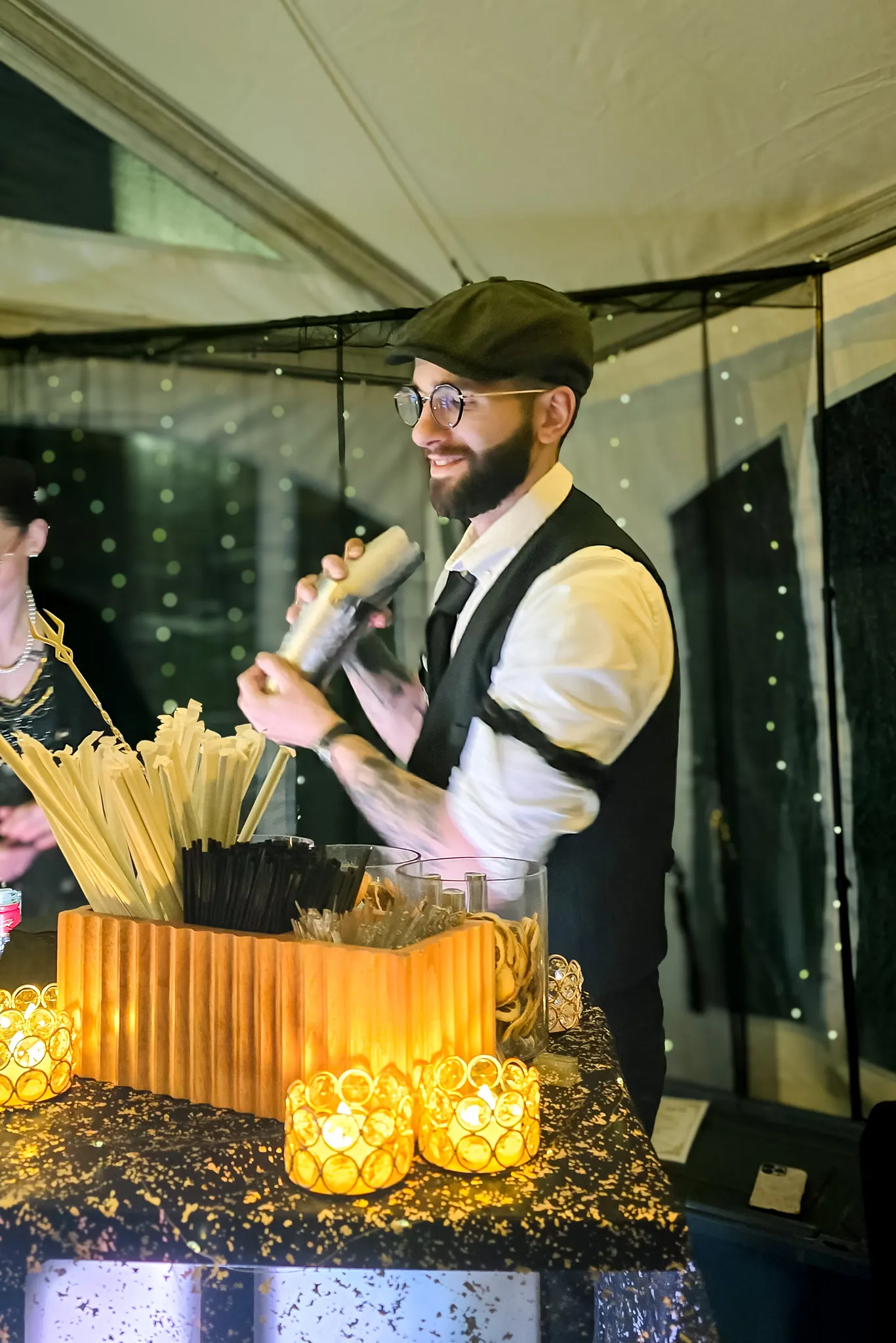 Split Base bartender shaking a cocktail behind the tented festival bar