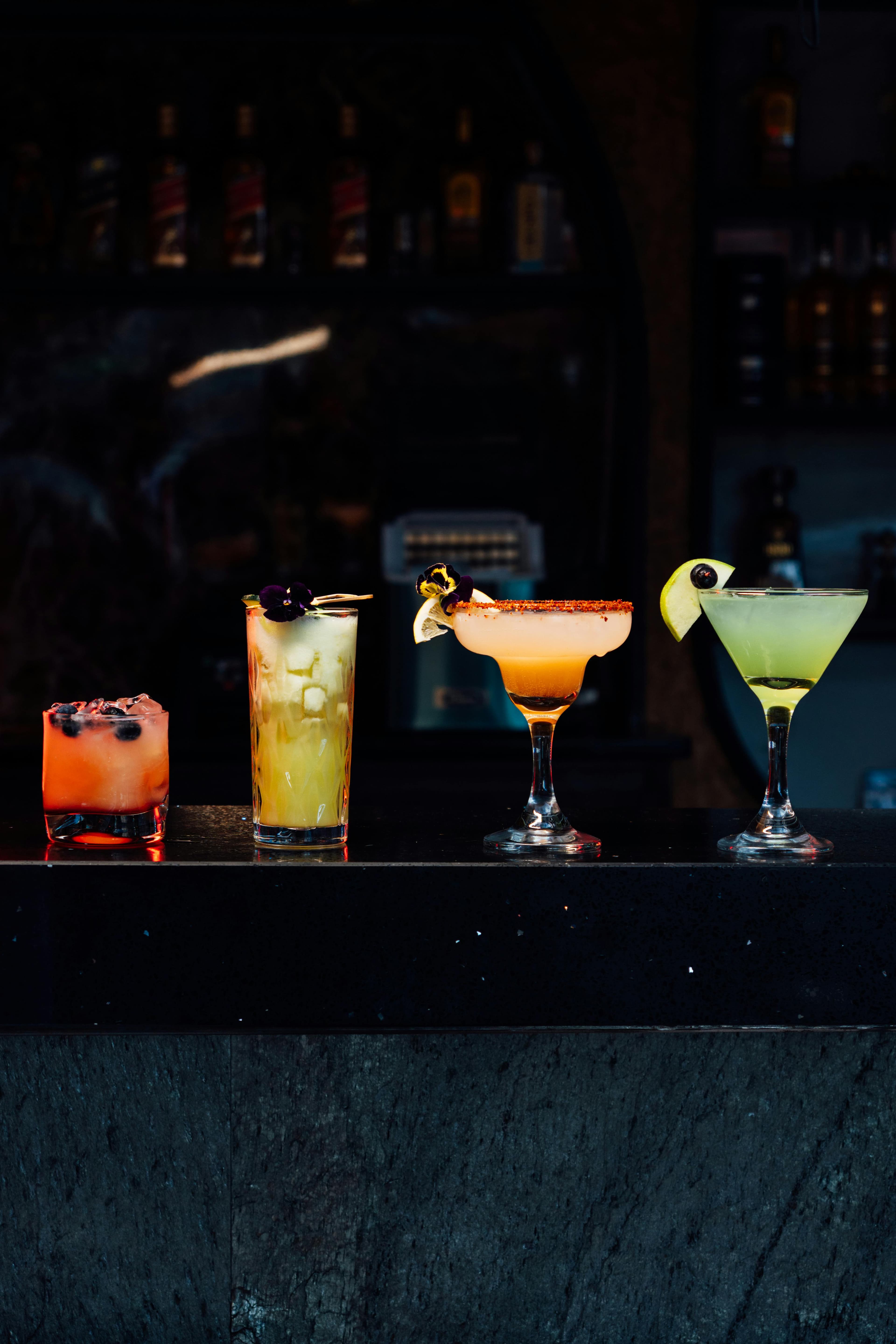 Craft Cocktails - bright colorful cocktails on a bar counter dark bg